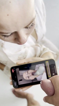 Cumtribute, une fille chauve nettoie son téléphone après
