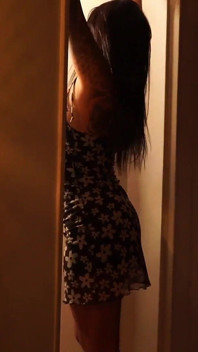 Latina sensual fazendo striptease com pouca luz