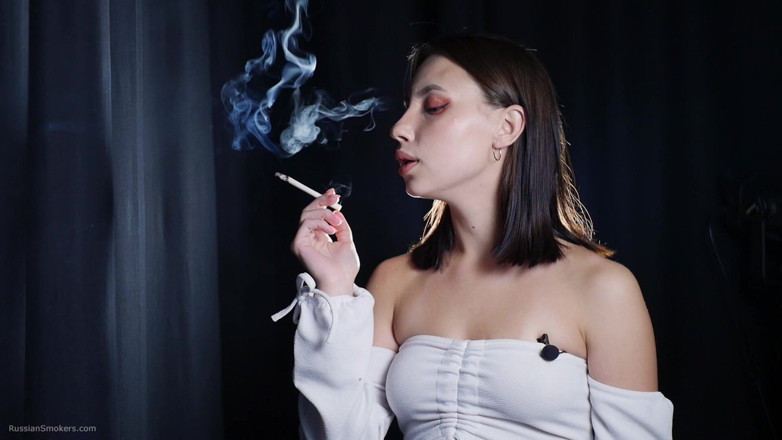 Russian Smokers: Elegante morena fumando cigarro em cena de estúdio escuro