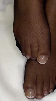 Ebenholz-mädchen zeigt ihre französische pediküre in ihren schwarzen nylons & zieht aus, um ihre füße zu zeigen