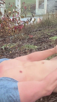 Músculo asiático destrozado se desnuda bajo la lluvia y acaricia junto a la carretera