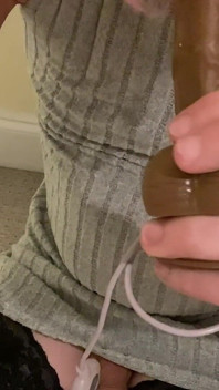 Sissy Crossdresser en robe moulante et bas hauts cuisses avec une culotte gaine à manches de bite s’exhibe et suce un gros gode