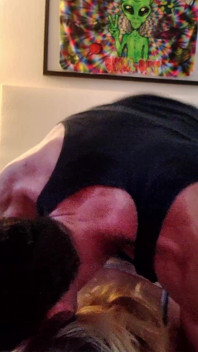 Sieh ihre gegenüber gerichtete kamera, während sie doggystyle direkt vom bett ist
