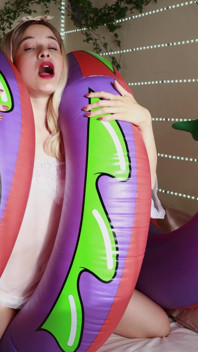 Seksi bir kız kışkırtıcı iç çamaşırlı şişme bir yılana biniyor