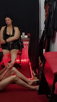 Dominatrix de látex con curvas sujeta y dilata esclavo enmascarado