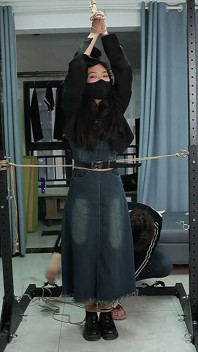 彼女は金属の台に固定されていて、くすぐられています
