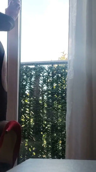 In intimo e tacchi alla finestra con un giocattolo