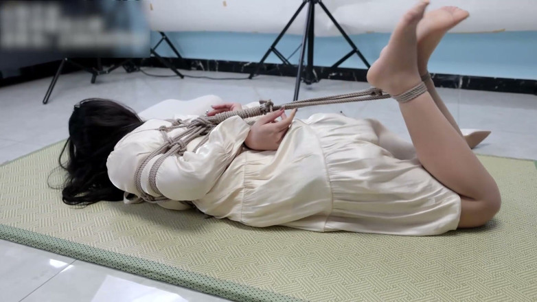 Asian bondage: Dziewczyna w sukience i pończochach, związana liną