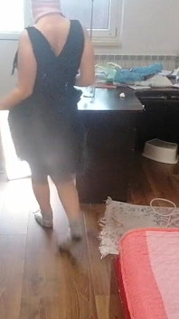 O femeie amatoare se distrează încercând hainele și tăindu-le