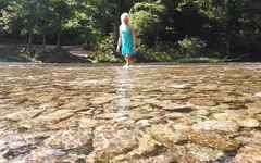 La trans sexy che nuota nel fiume di montagna con bagna i vestiti estivi...