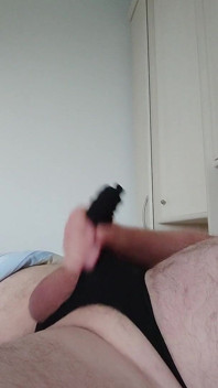 Excitat masturbându-se în tanga neagră pentru penis