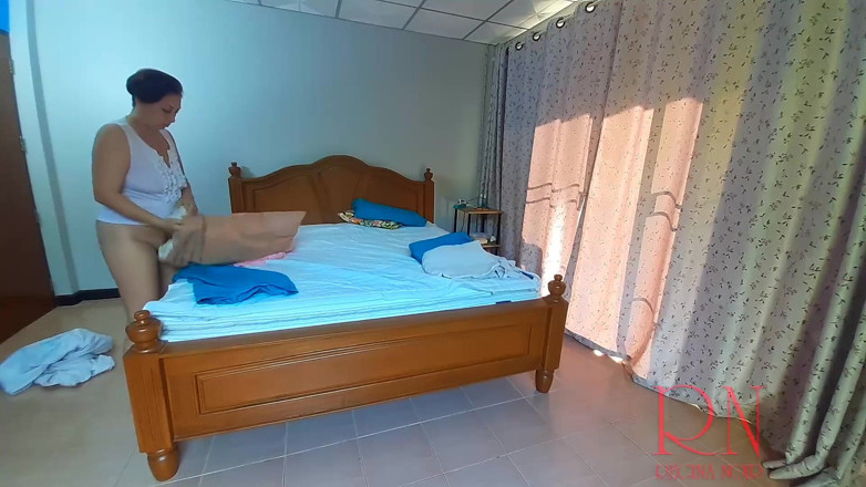 Regina Noir: Menajera nudistă Regina Noir face lenjeria de pat în dormitor. Servitoare...