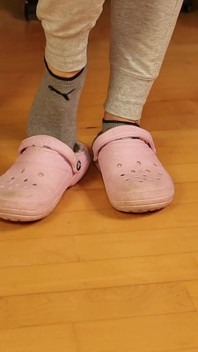 Calcetines grises sucios en zuecos rosas - provocación casual de pies