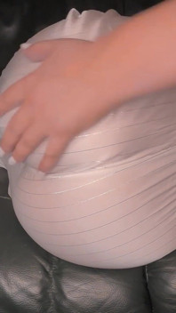 Furzen im weißen Satin-schlafanzug auf grünem Leder sofa