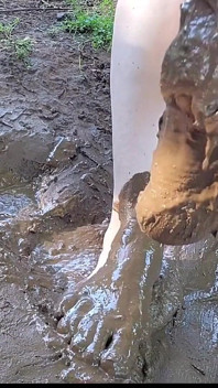 Descalzo chorros y jugando en el barro, pies sucios