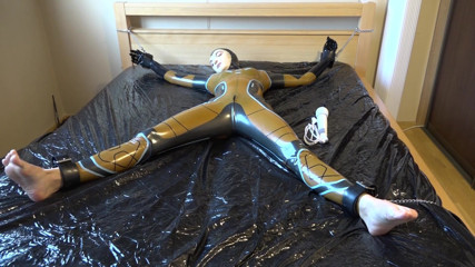 Latex Danielle: Latex Danielle is attached to the bed and masturbated with...