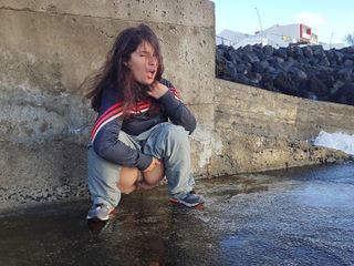 Pissing Everywhere: 一个穿着运动服的可爱快感女孩坐在海边撒尿