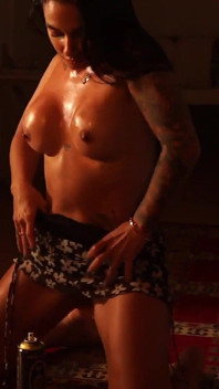Latina sensuale che fa striptease con poca luce