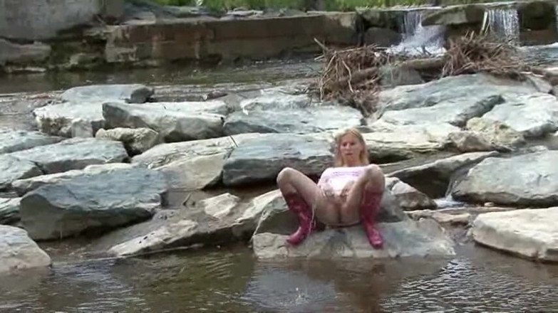 Femdom Austria: Blonde pissing outside in a river