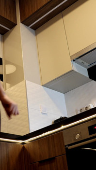 Une nouvelle femme brune sexy dans la cuisine sans culotte avec des collants noirs vérifie les appareils ménagers