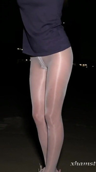 Anna dalam pantyhose berkilat putih di pantai malam