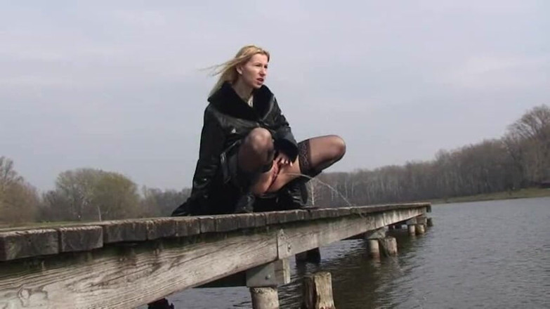 Femdom Austria: Bitch in leather pissing on a pier