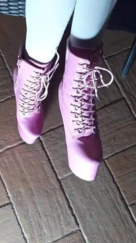 Assis sur une chaise en collants et bottes à talons hauts