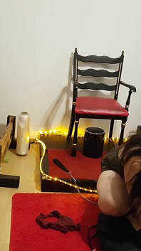 가죽 노예에게 얼굴을 내미는 매력적인 Dominatrix