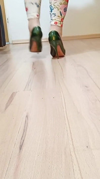 Un travesti marche dans des escarpins à talons hauts en cuir de serpent sexy