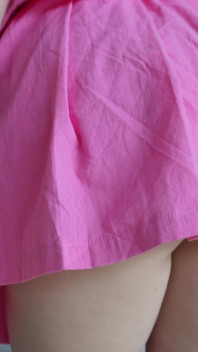 Dlouhovlasá brunetka v růžové sukni škádlí a hraje si s análním kolíkem
