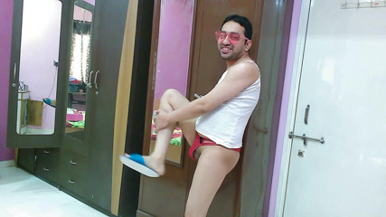 Cute & Nude Crossdresser: 性感的娘娘腔变装者femboy Sweet棒棒糖在中音，丁字裤，太阳镜和人字拖。