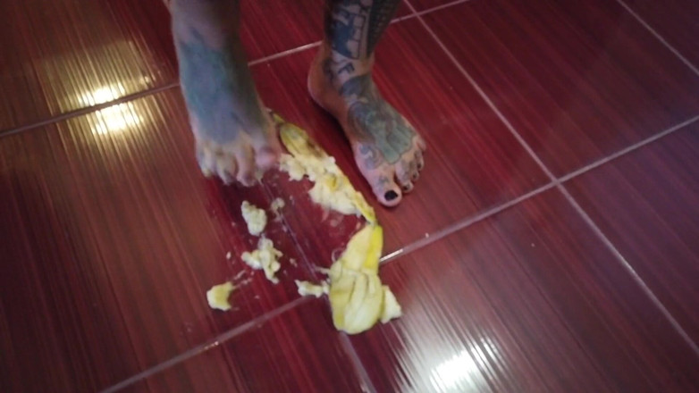 Fetish videos by Alex: Een banaan wordt vertrapt door een blonde getatoeëerde milf