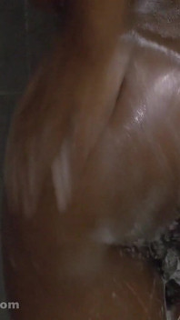 Une femme musclée pisse sous la douche