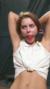 Leya è legata su una sedia e sbava attraverso ballgag