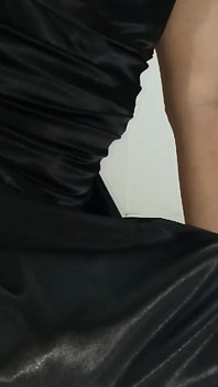 Travestito che indossa un abito nero di raso si masturba scivoloso