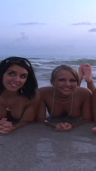 3人の美女が公共のビーチでキスをし、トップレスになる