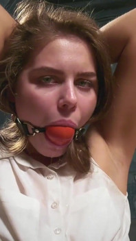 Leya è legata su una sedia e sbava attraverso ballgag