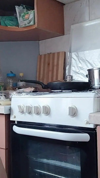 Bini bogel seksi menyediakan makanan di dapur. Si rambut coklat berbulu, pantat besar, tetek besar.