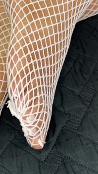 Ébano menina mostra seus pés com pedicure francês em suas meias brancas