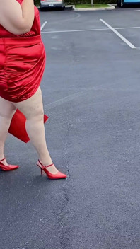 Bela mulher andando ao ar livre no estacionamento se exibindo para estranhos