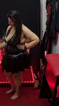Une maîtresse pulpeuse en latex serre et dilate un esclave masqué