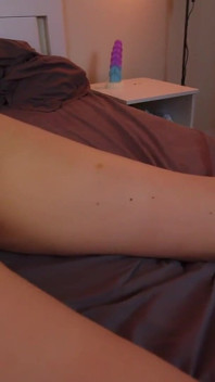 Une blonde sexy ligotée se masturbe sur le lit.