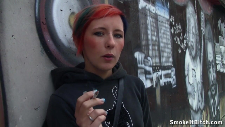 Smoke it bitch: Une fille aux cheveux colorés et un visage percé fume...