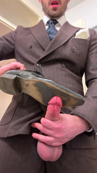 Homme d’affaires en costume se branle sur ses chaussures en cuir verni