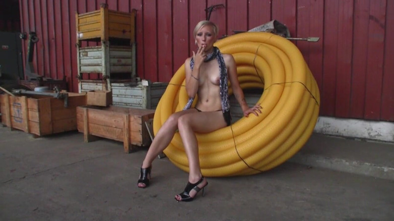 Facial flavor: Blondes mädchen in high heels sitzt nackt in der fabrik...