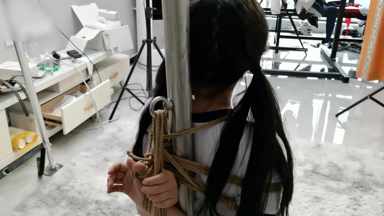 Asian bondage: Teman wanita berstoking putih diikat pada tiang besi dengan tali,...
