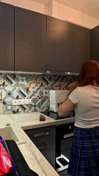 Fata juggler este aici într-o fustă lungă de uniformă colegiu de tip să-și expună chiloții sub fustă mini în bucătărie
