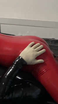 O mamă sexy incitantă în costum roșu de latex îi face o muie dură și o ejaculare mare