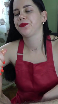 Mooie huisvrouw met rode lippenstift zuigt pik