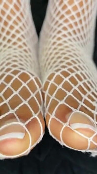 Une black exhibe ses pieds avec une pédicure française dans ses filets de pêche blancs